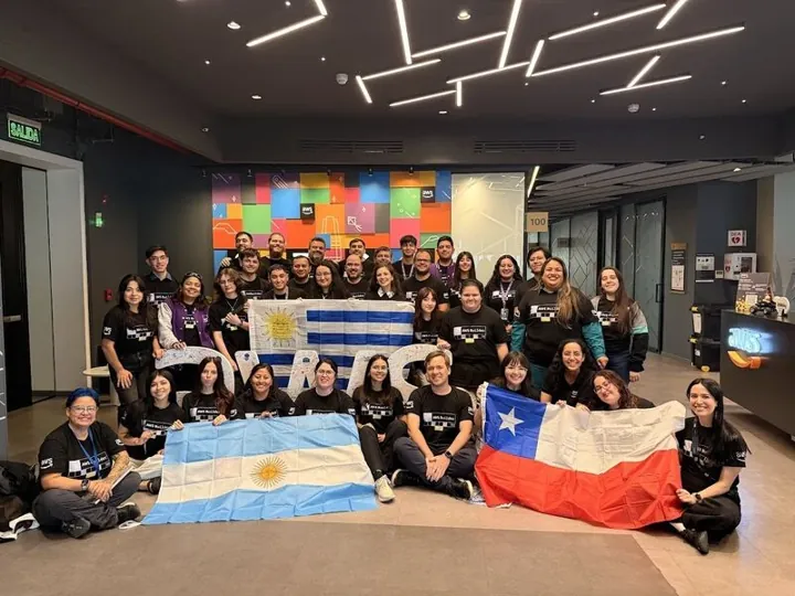 Grupo de líderes de comunidades AWS con las banderas de Argentina, Uruguay y Chile